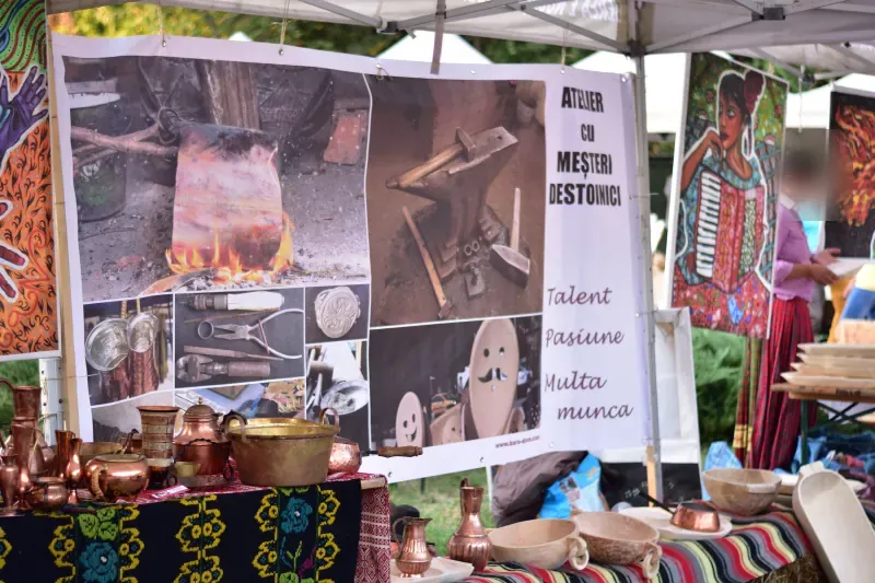 Standul „Atelier cu meșteri destoinici” de la Balkanik Festival, cu vase de cupru și obiecte din lemn